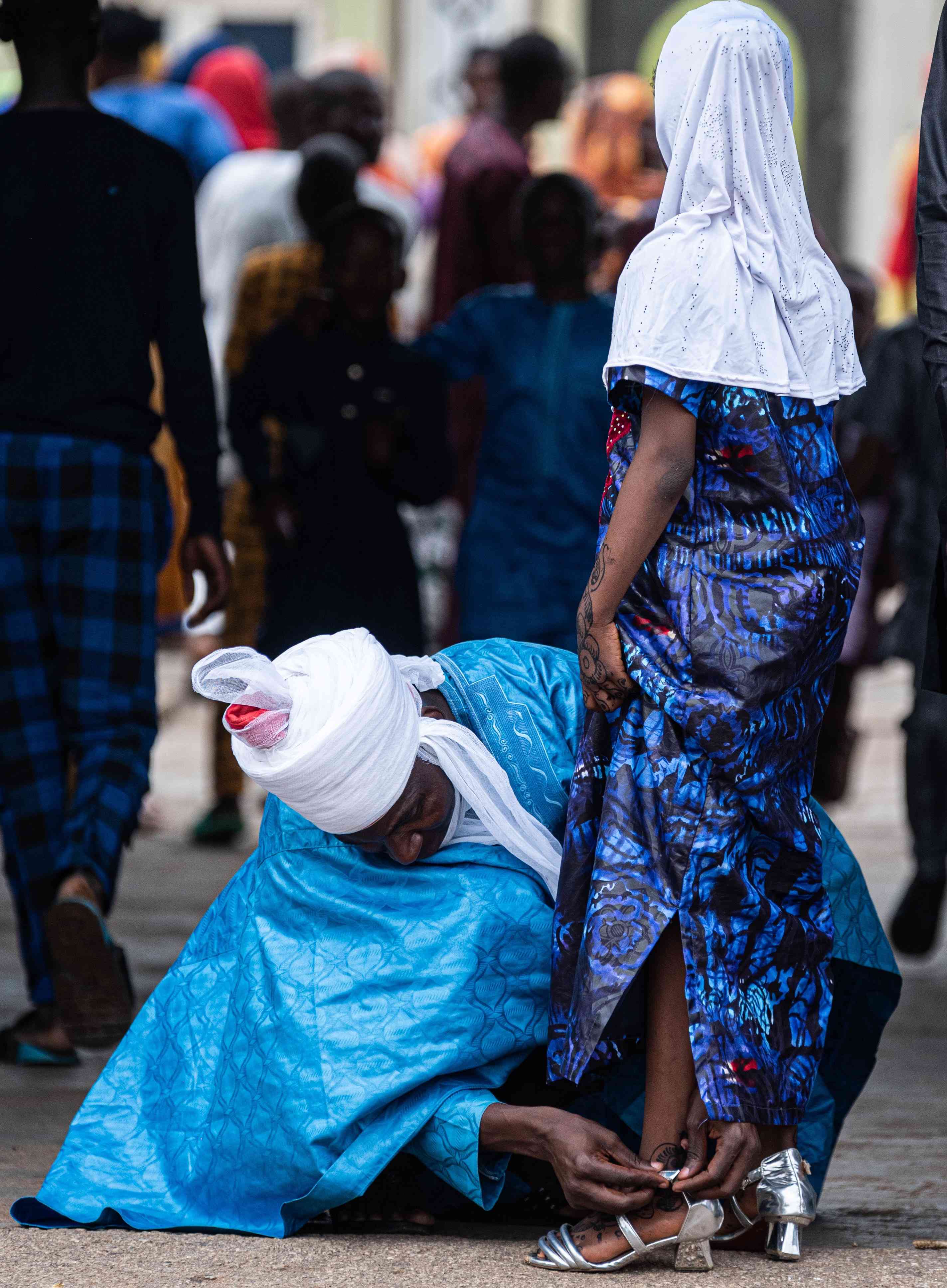 A father helping his daughter with her shoes during Eid celebration in Ilorin caught on camera | MirrorLog